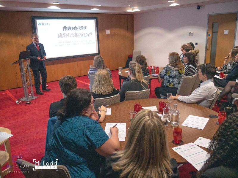 An IAM speaker teaching a project management session to a seated cohort