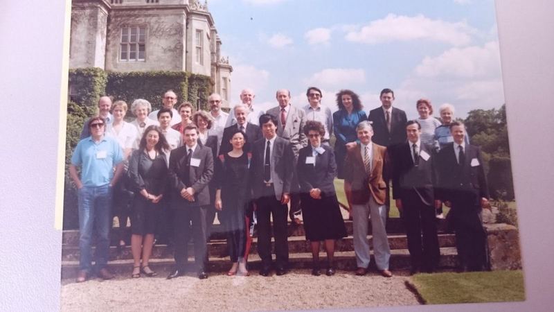 Colour archive photograph of an international group of IAM members on the steps of a country house