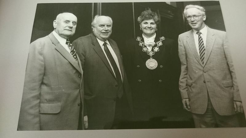 Archive photograph of three men with a woman wearing a ceremonial chain of office