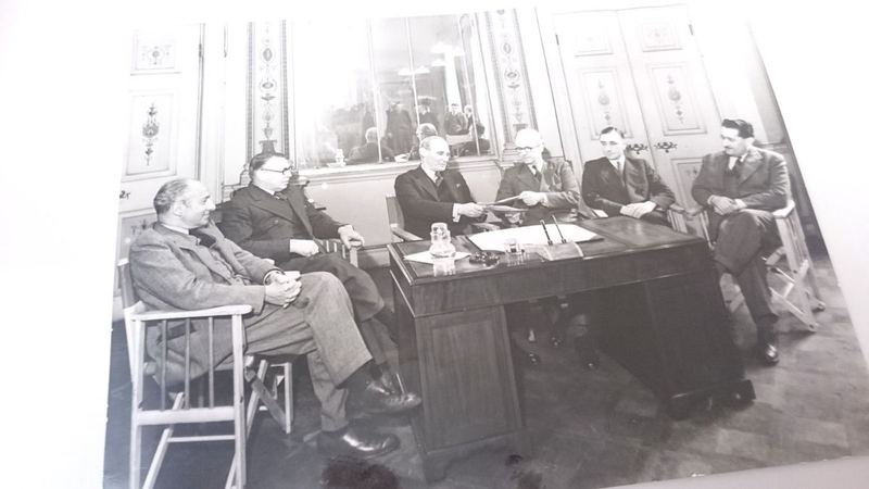 Archive photograph of a council meeting around a desk in a panelled room