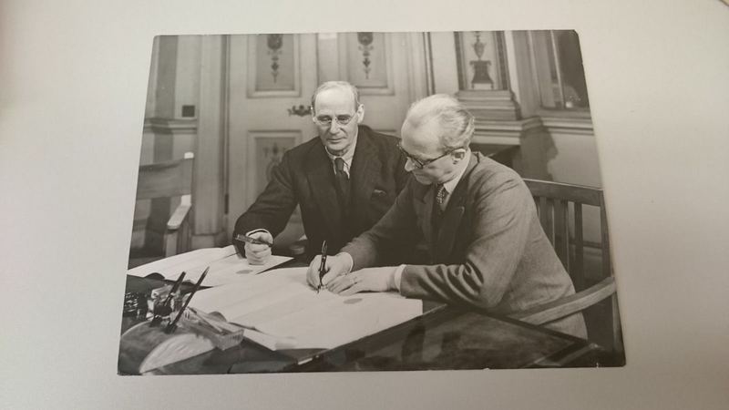 Archive photograph of two officials signing documents at a desk